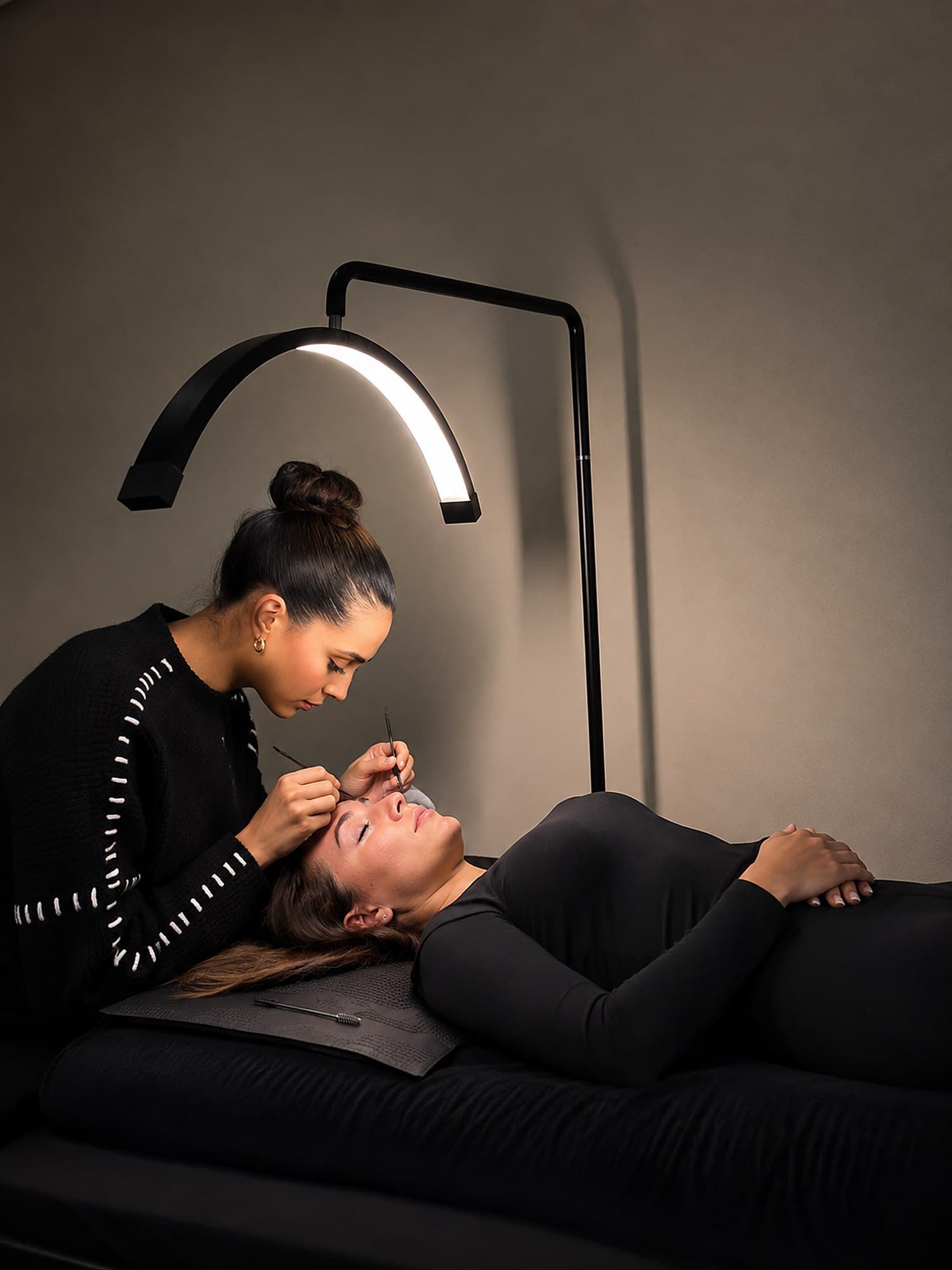 Elysza en train de poser des extensions de cils sur une cliente, dans son atelier